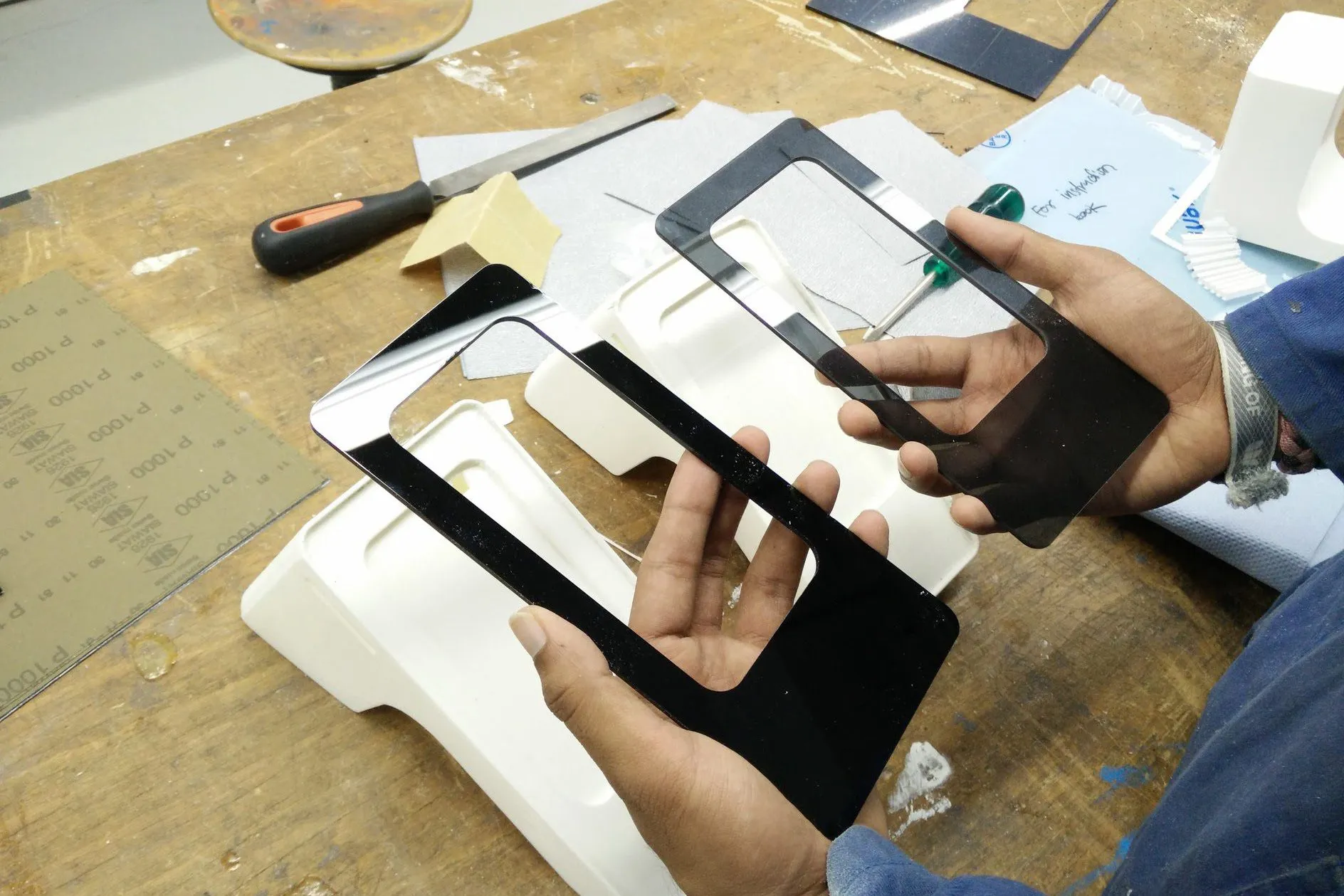 Fitting cut acrylic faces to the final model bodies in the workshop.