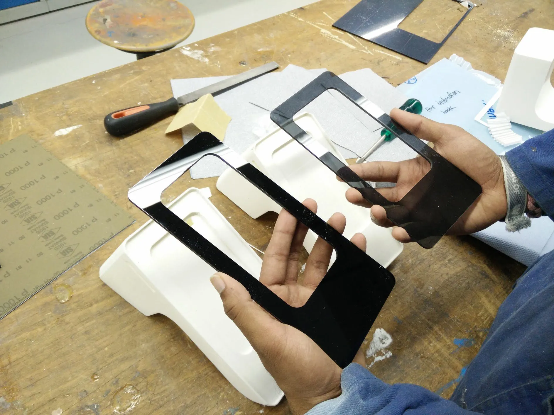 Fitting cut acrylic faces to the final model bodies in the workshop.
