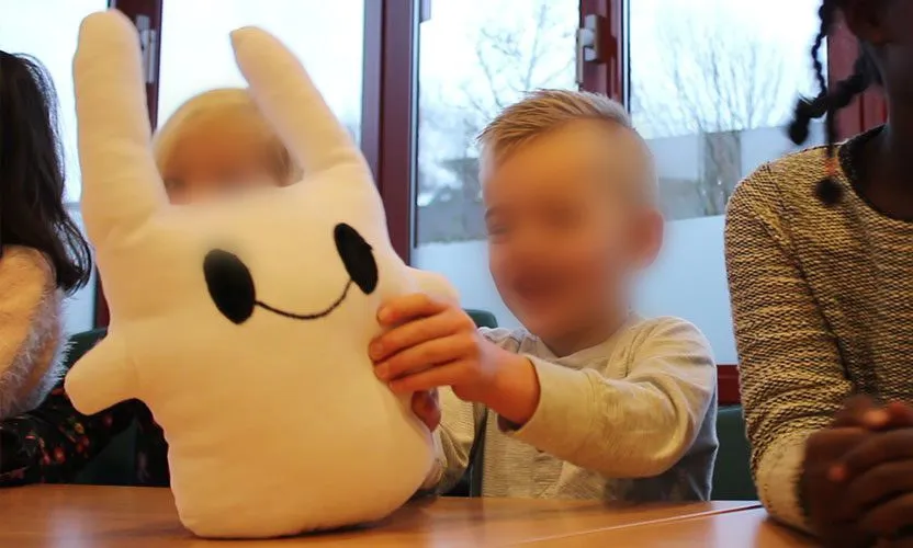 A child at the school test holding one of the prototypes, faces softly blurred for privacy