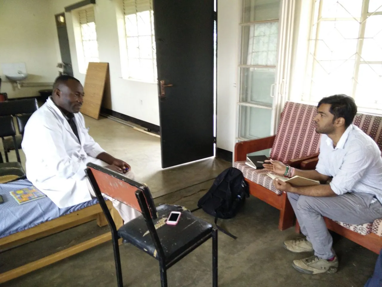 A clinical officer describing his diagnostic process to me, in a room with a bed, two chairs and no equipment.