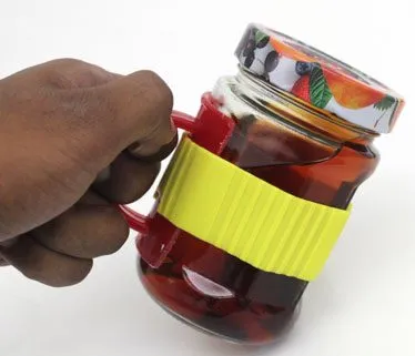 A hand carrying the jar of tea by its handle with the lid screwed on