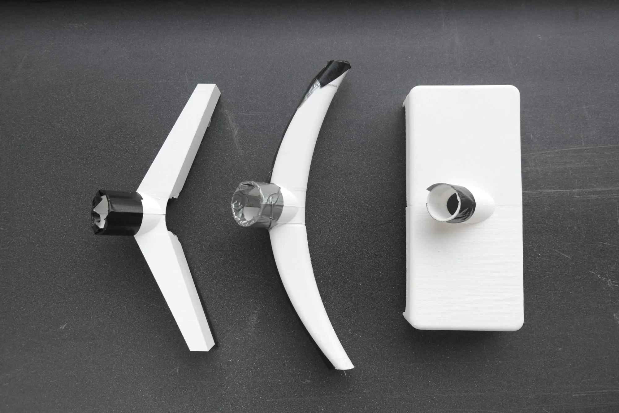Three printed nozzle forms, taped to tube stubs so they could be tested on an existing vacuum cleaner.