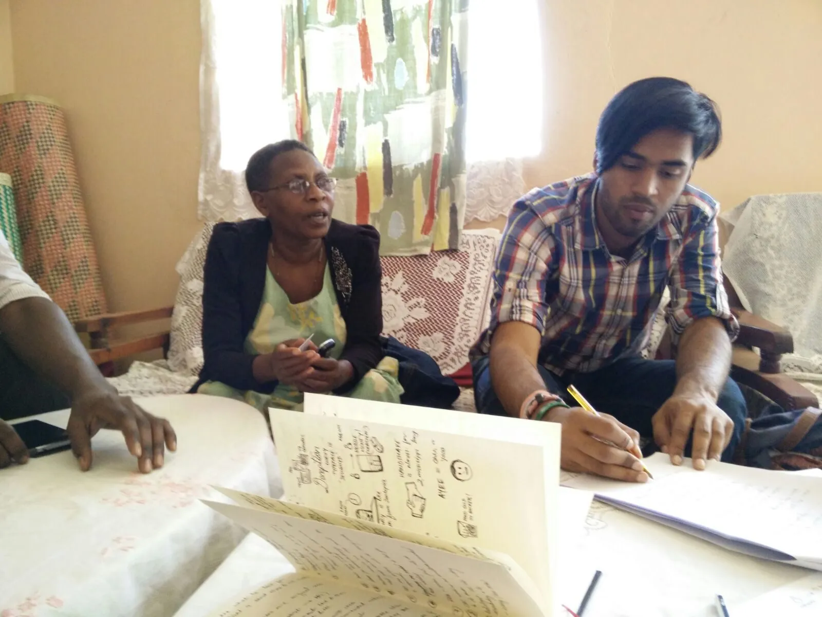 Mapping a patient's route with a village health team member, in her front room.