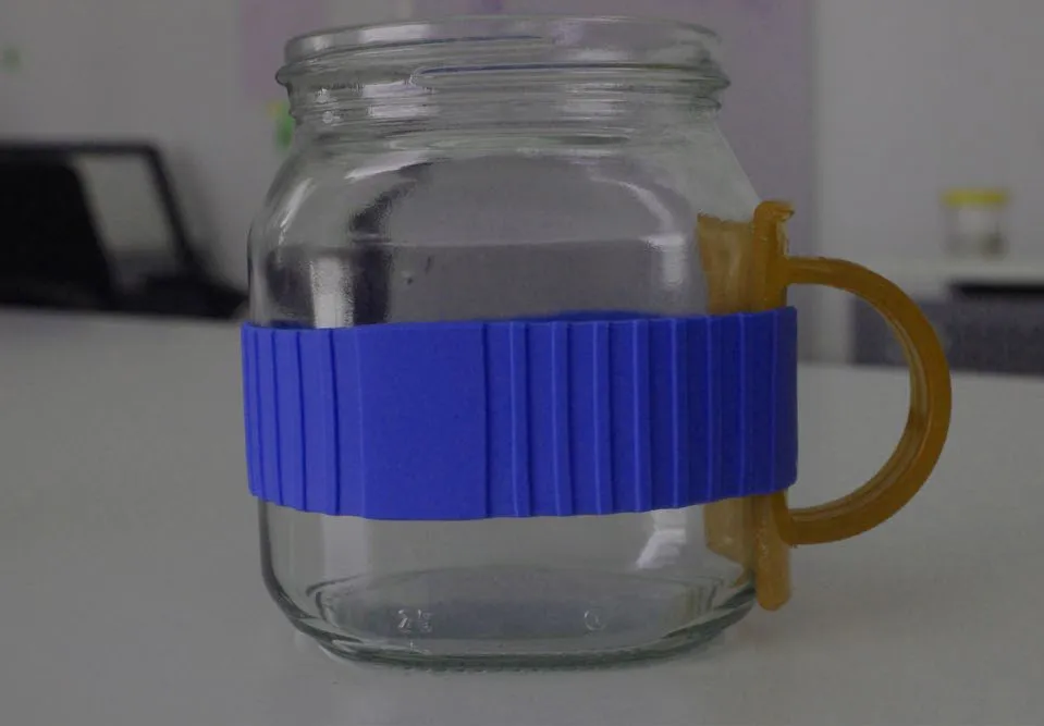 A 3D printed translucent handle held to a plain jar by a blue ribbed band