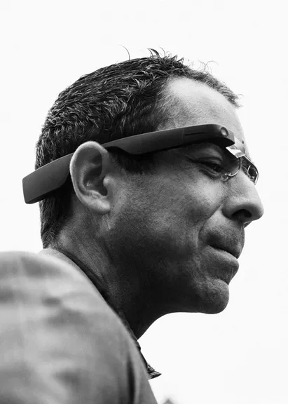 A black and white profile portrait of a man wearing Envision Glasses, looking out past the camera.