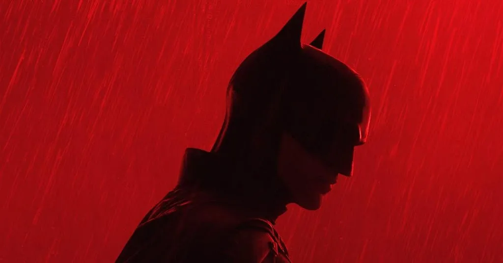 silhoute of batman amidst a red glow and rain